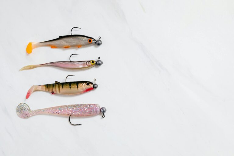 Four fishing lures lined up on a white background in a studio setting.