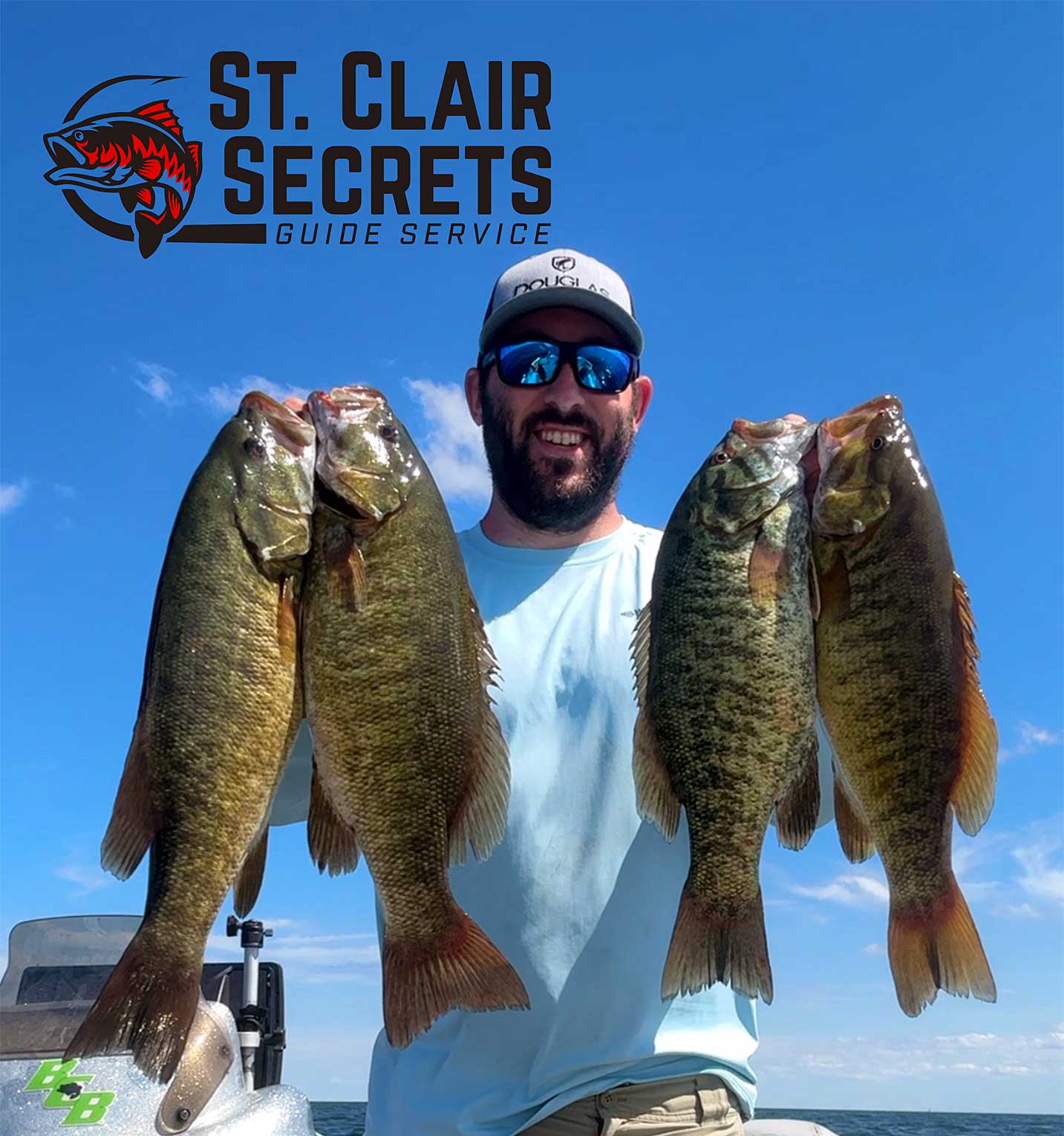 Captain Tyler Smith with 4 big smallmouth bass and logo